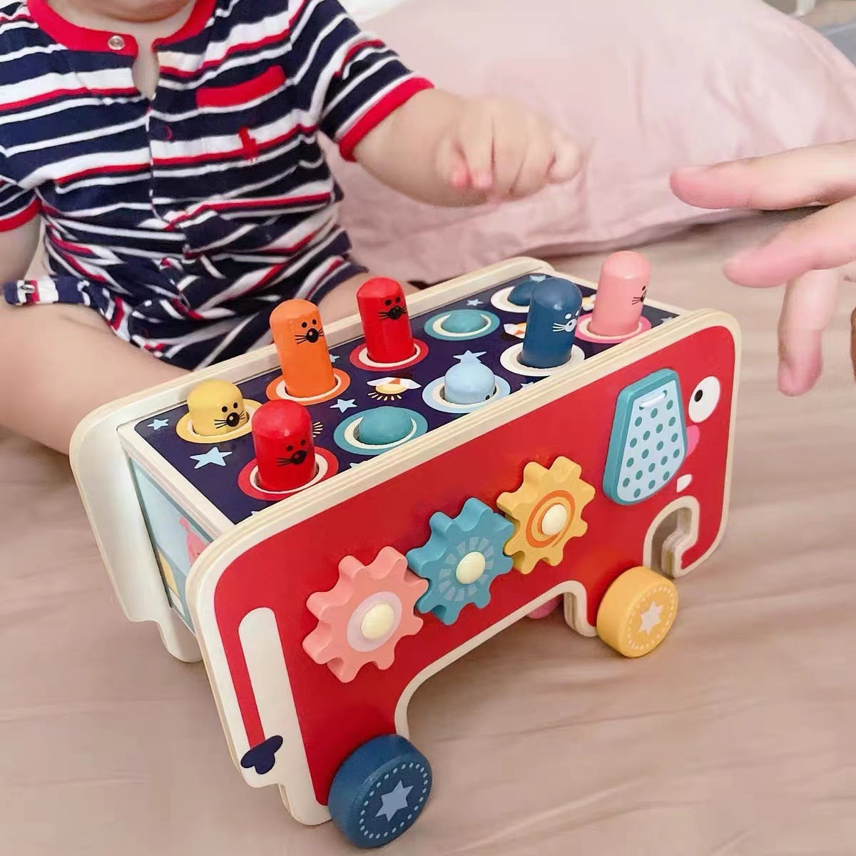 Parent and child play with elephant hammering pegs