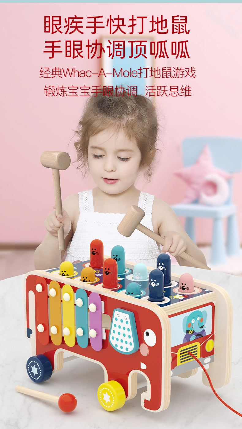 Child using wooden mallet to play elephant xylophone