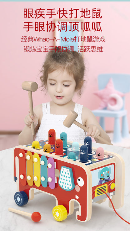 Child using wooden mallet to play elephant xylophone
